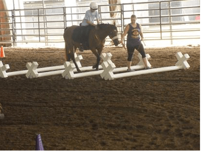 Woman walking a horse while a child rides the horse